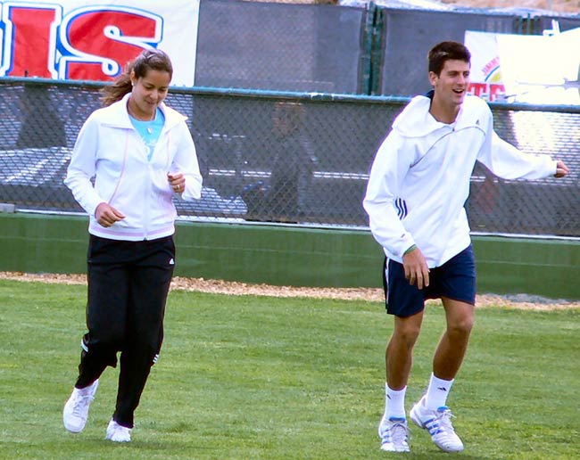 Novak Djokovic and Ana Ivanovic jog and stretch before practicing