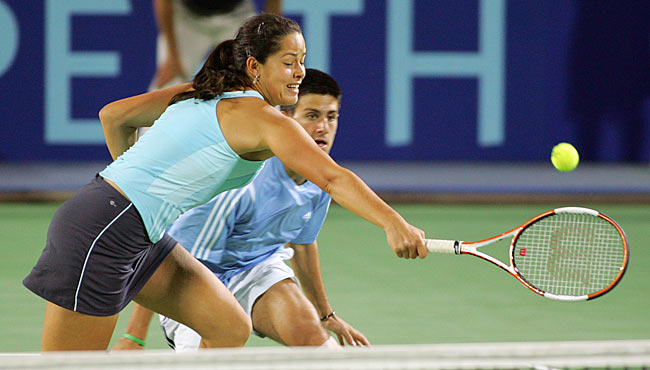 Ana Ivanovic (L) of Serbia and Montenegro reaches for a shot at the net as compatriot Novak Djokovic during their mixed doubles match against Sofia Arvidsson and Thomas Johansson of Sweden during the Hopman Cup in Perth, Australia January 2, 2006. Serbia and Montenegro won the match 6-2 6-4.